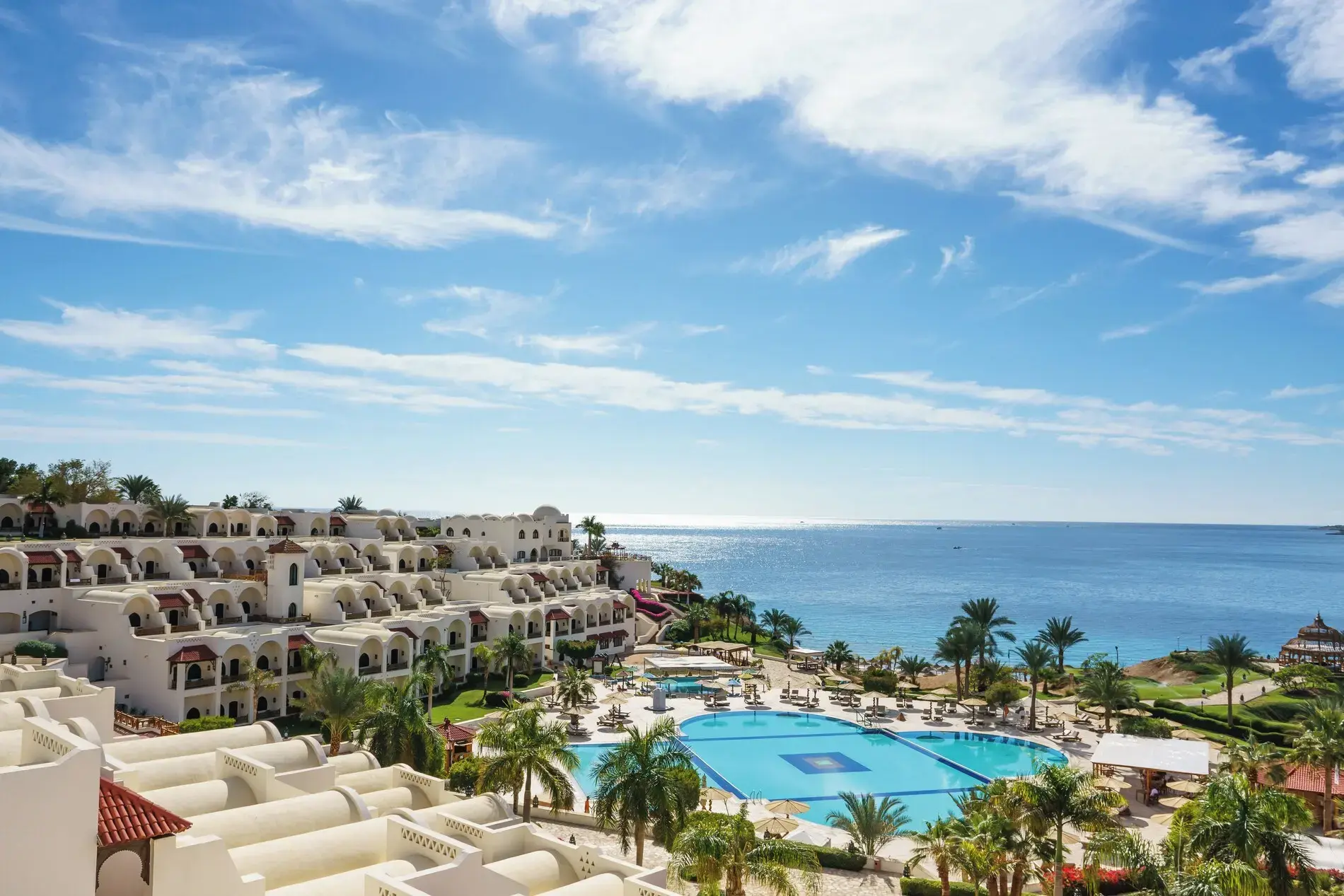 Терасирани бели сгради над голям басейн и Червено море – Mövenpick Resort Sharm El Sheikh, Шарм Ел Шейх
