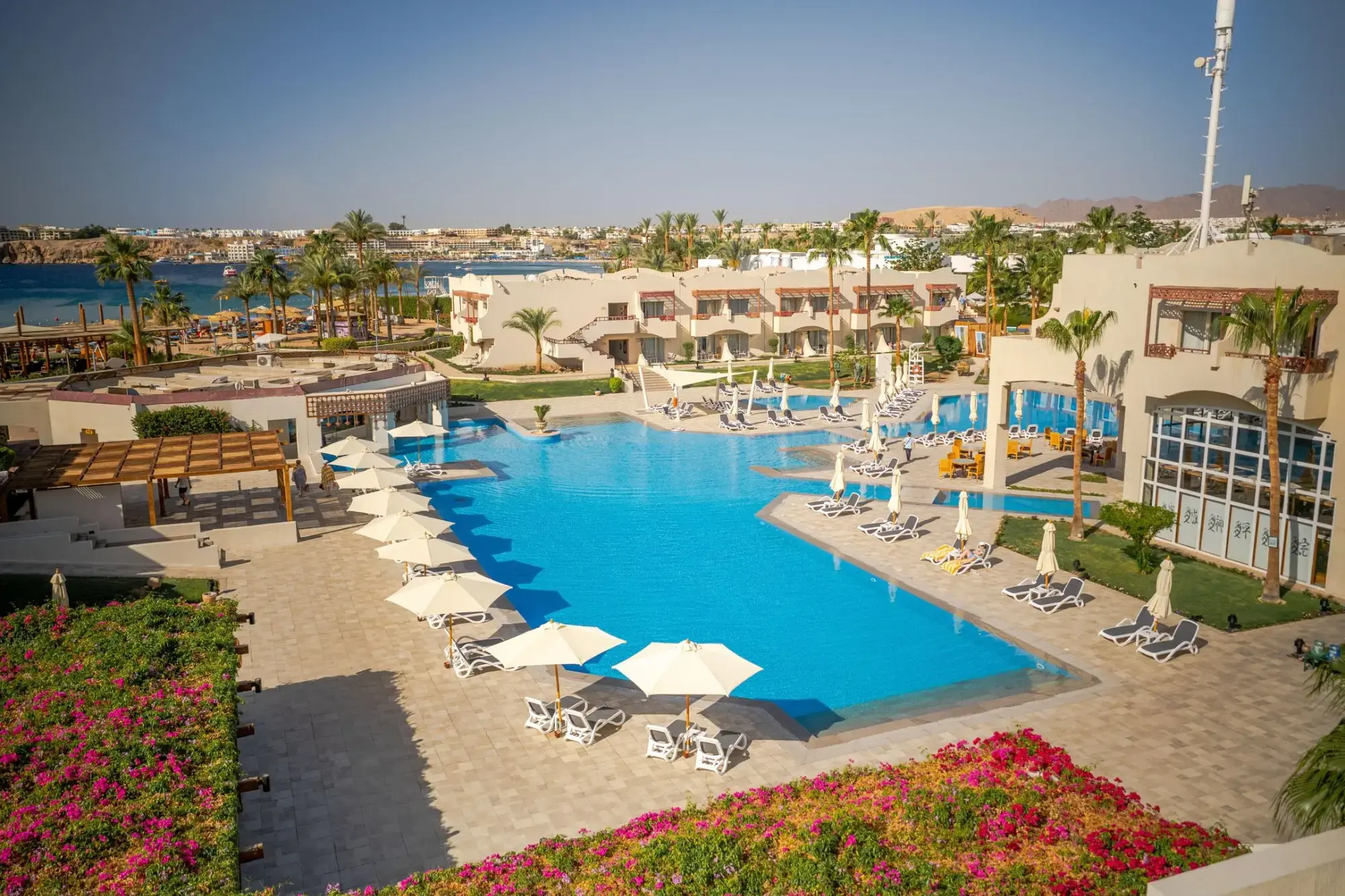 Басейн с чадъри и бугенвилии, а зад него морето, изглед отвисоко – Naama Bay Promenade Beach Resort, Шарм Ел Шейх