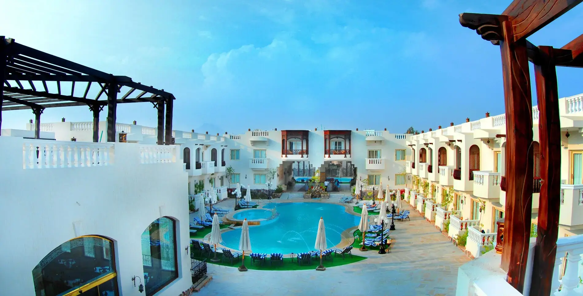 Басейн сред бели сгради с ориенталски тераси по залез в Наама Бей – Oriental Rivoli Hotel & Spa, Шарм Ел Шейх