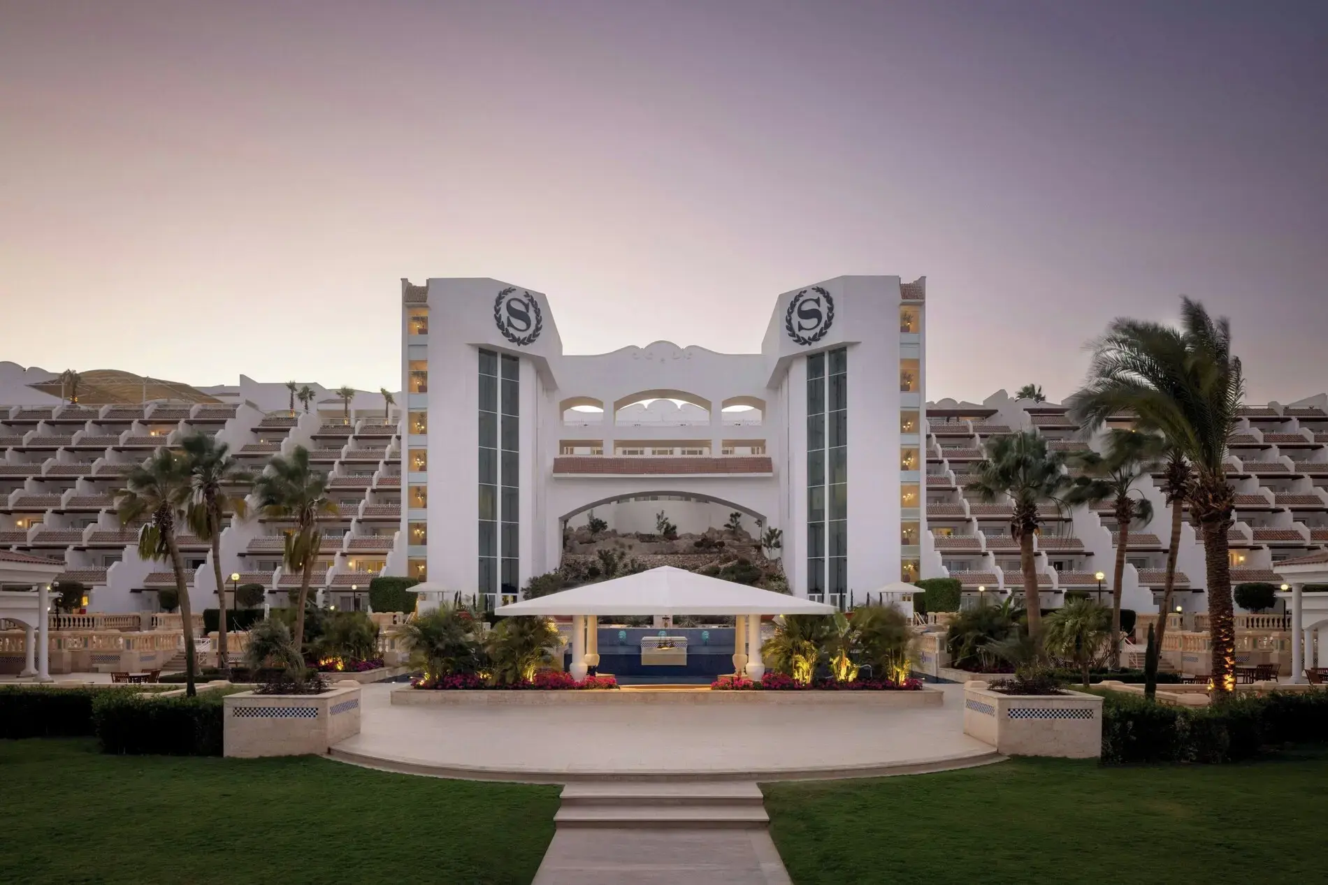 Фасада с логото на Sheraton и терасовидните корпуси по здрач – Sheraton Sharm Main Building, Шарм Ел Шейх