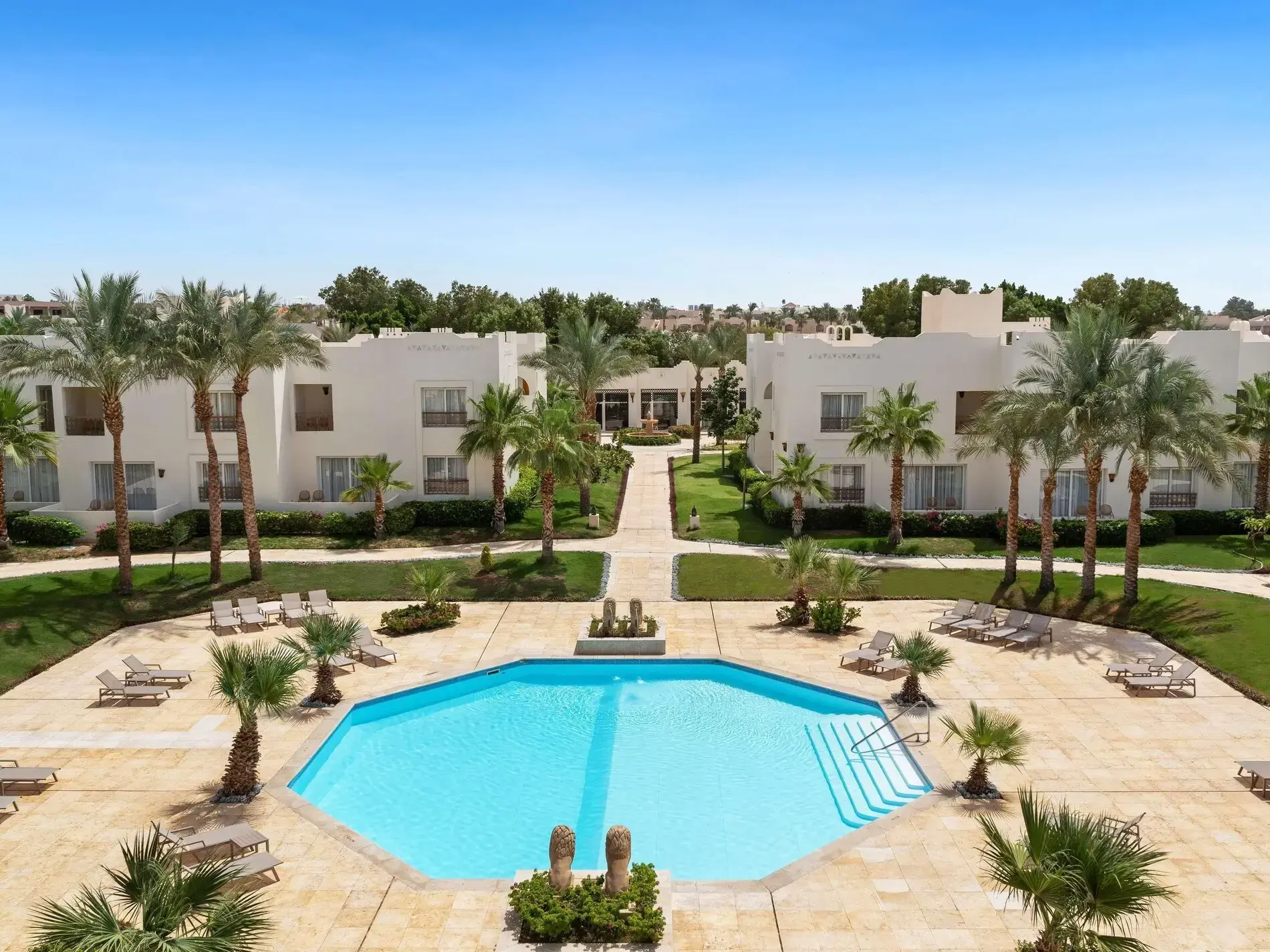 Басейн сред палми и морави пред белите сгради – Swissôtel Sharm El Sheikh All Inclusive Collection, Шарм Ел Шейх