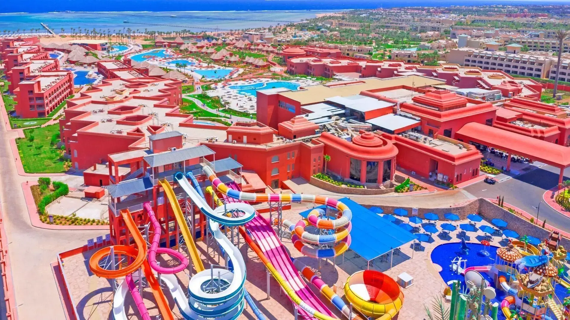 Аквапарк с цветни пързалки сред червените сгради на комплекса – Pickalbatros Laguna Vista Hotel, Шарм Ел Шейх