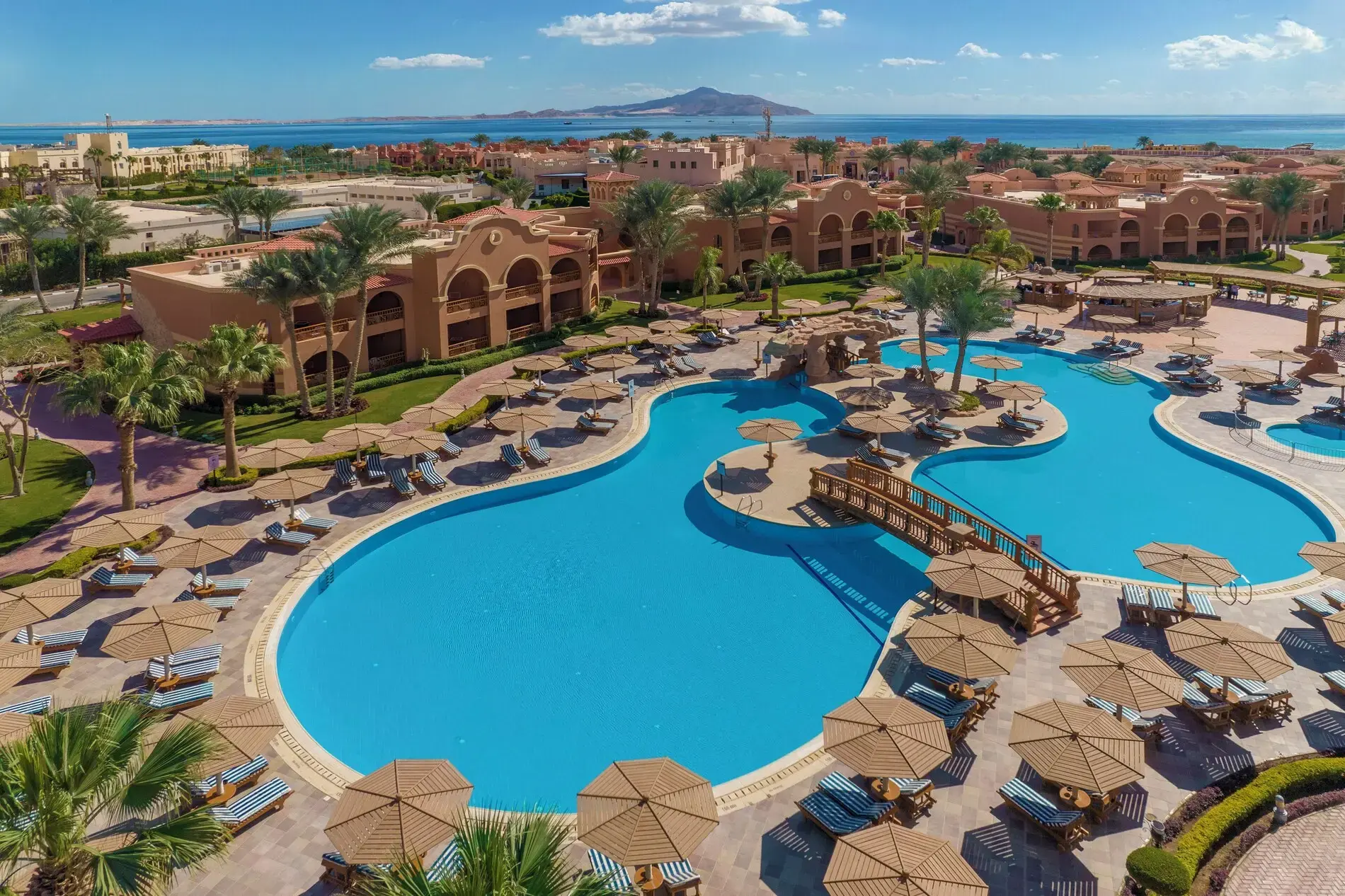 Изглед от въздуха към басейна с лагуна, сламени чадъри и морето – Charmillion Gardens Aqua Park, Шарм Ел Шейх