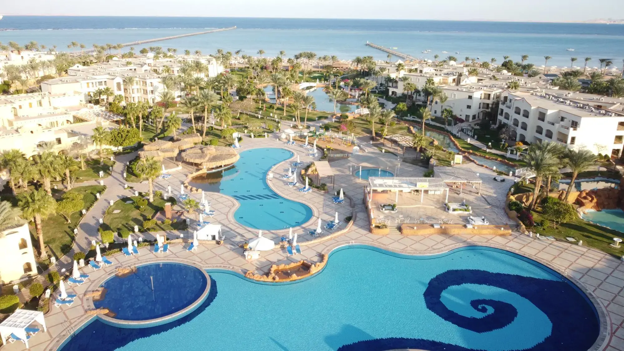 Басейни с извити форми сред палмите край морето от въздуха – Regency Plaza Aqua Park & Spa Resort, Шарм Ел Шейх
