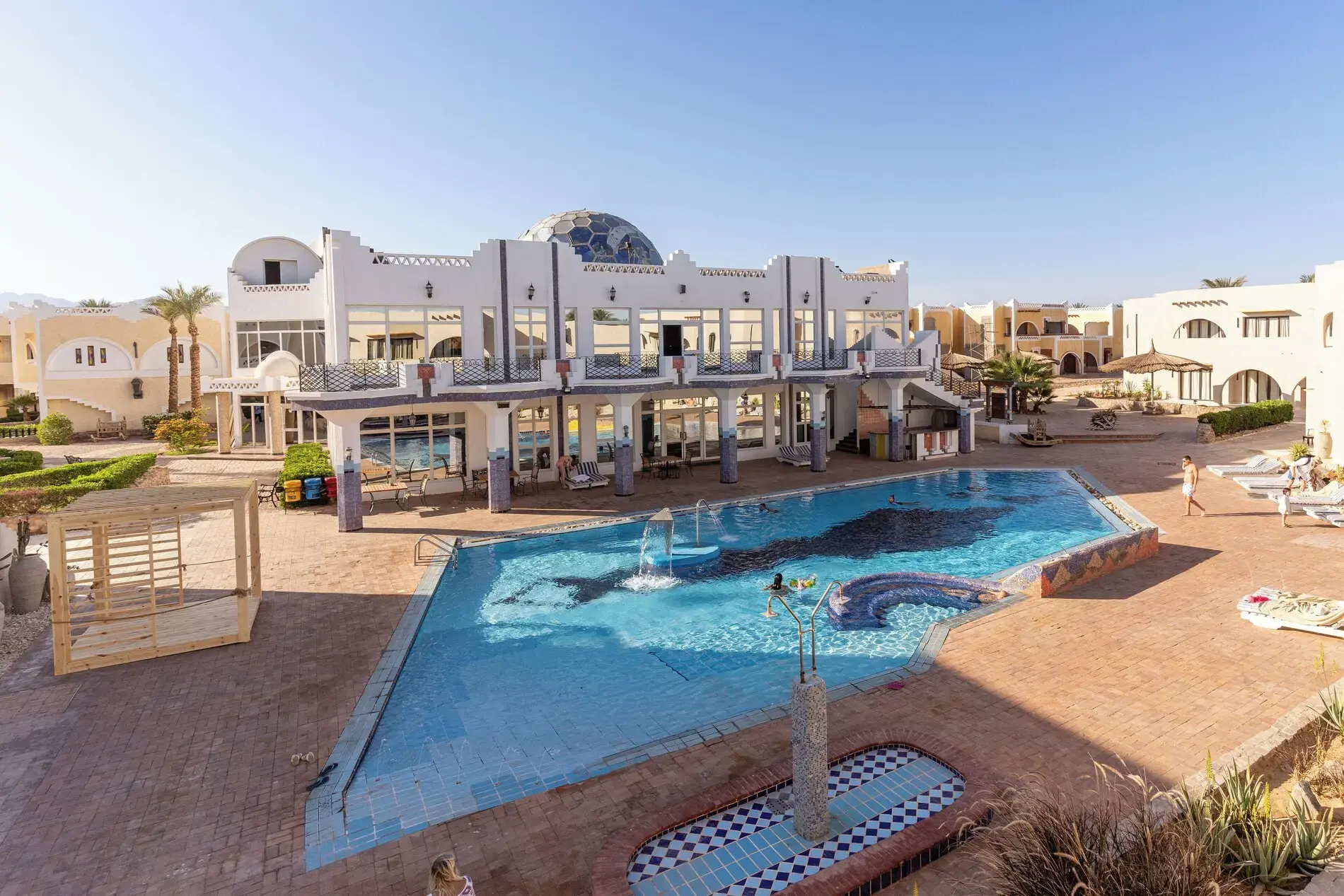 Делфин на дъното на басейн пред бяла сграда – Faraana Reef Resort, Шарм Ел Шейх