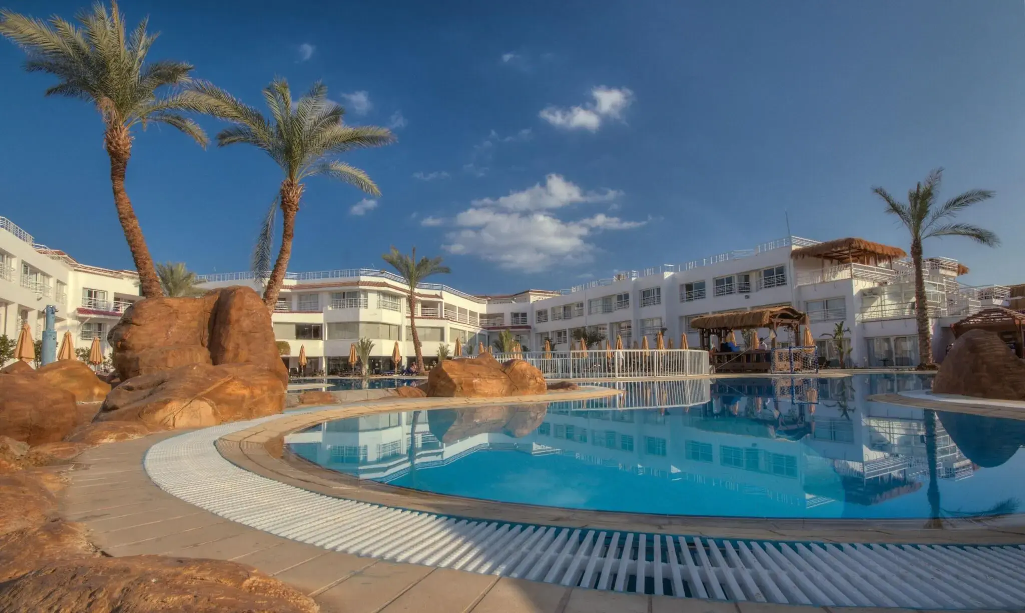 Лагуна басейн между скали и палми при синьо небе – Sharming Inn Hotel, Шарм Ел Шейх