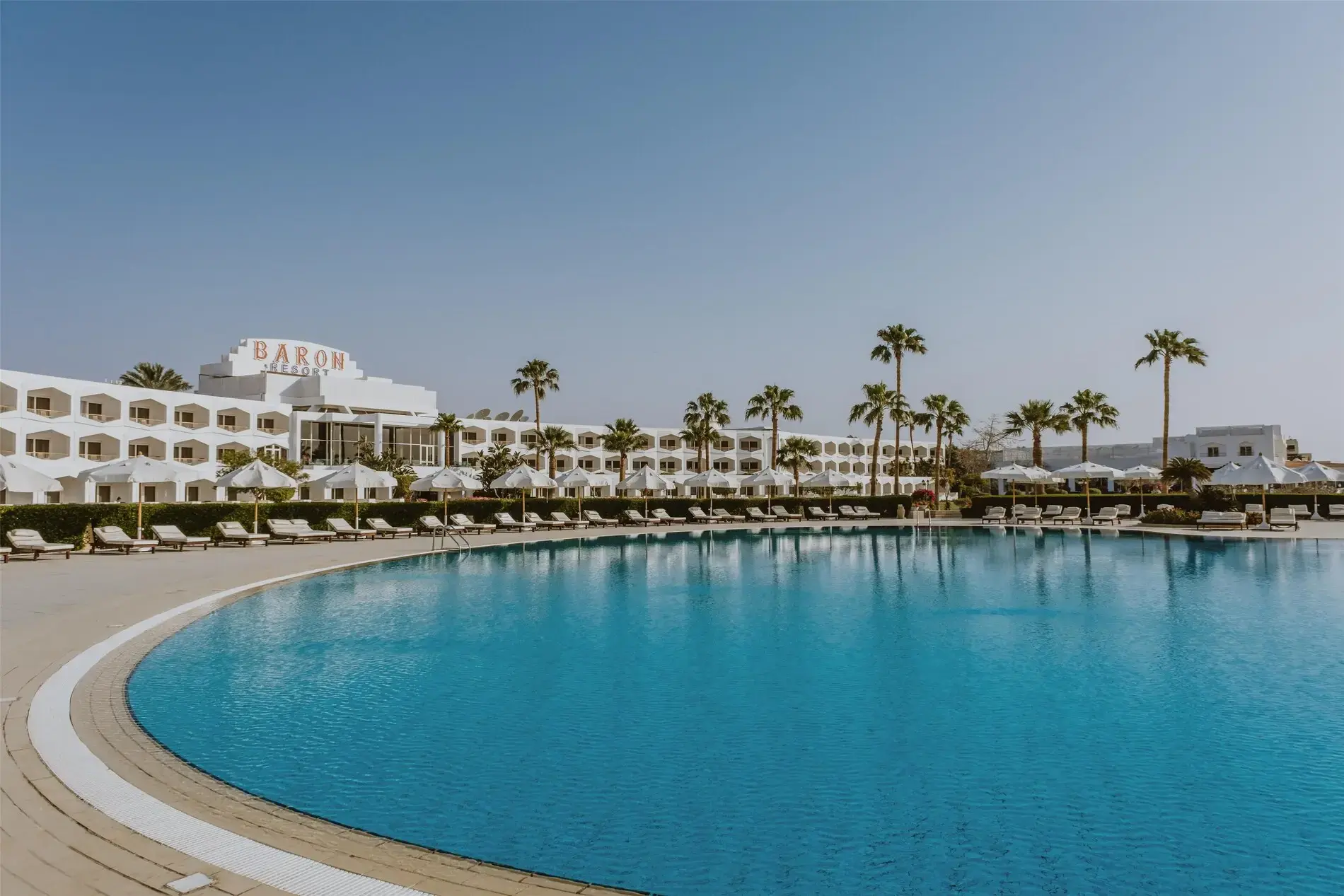 Басейн лагуна с плитък пясъчен бряг и бели сгради – Baron Resort Sharm El Sheikh, Шарм Ел Шейх