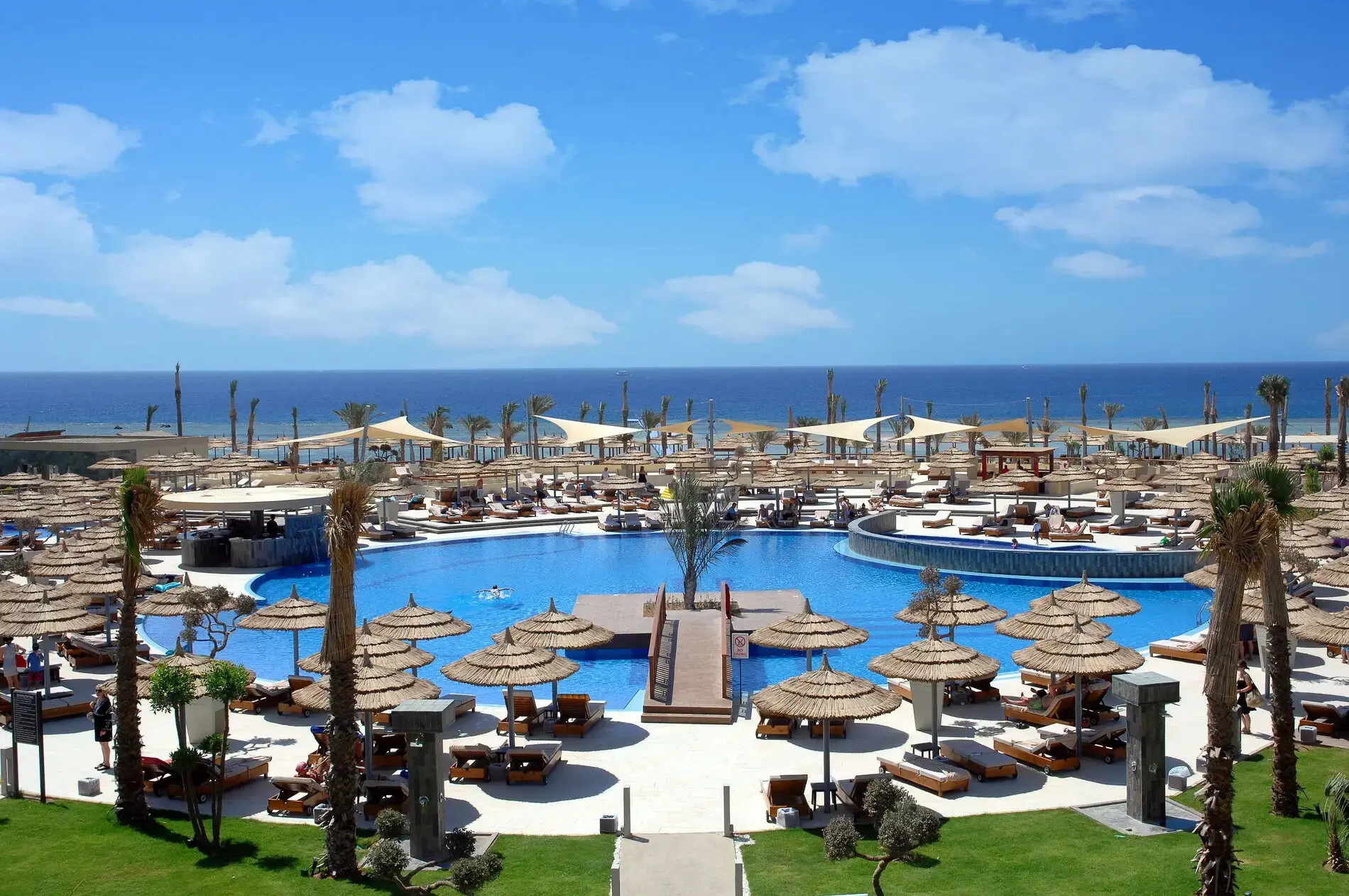 Панорама на басейните с чадъри и шезлонги край морето – Coral Sea Sensatori Resort, Шарм Ел Шейх