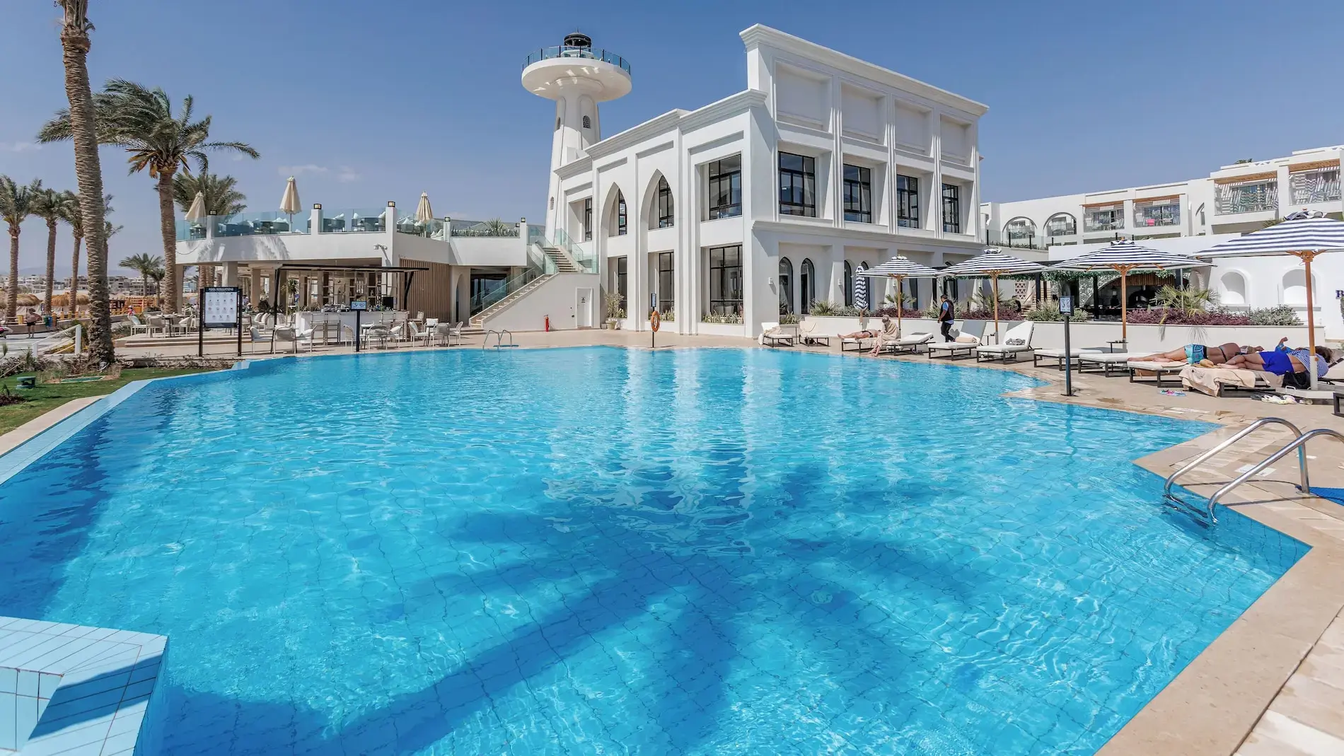 Основен басейн с шезлонги пред главната сграда и фара – SUNRISE Remal Beach Resort, Шарм Ел Шейх