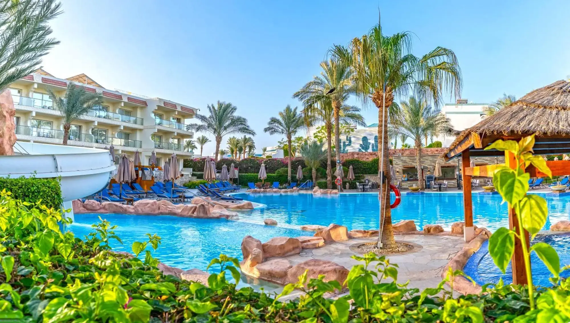 Лагунен басейн с каменни острови и палми пред жилищните сгради – Xperience Sea Breeze Resort, Шарм Ел Шейх