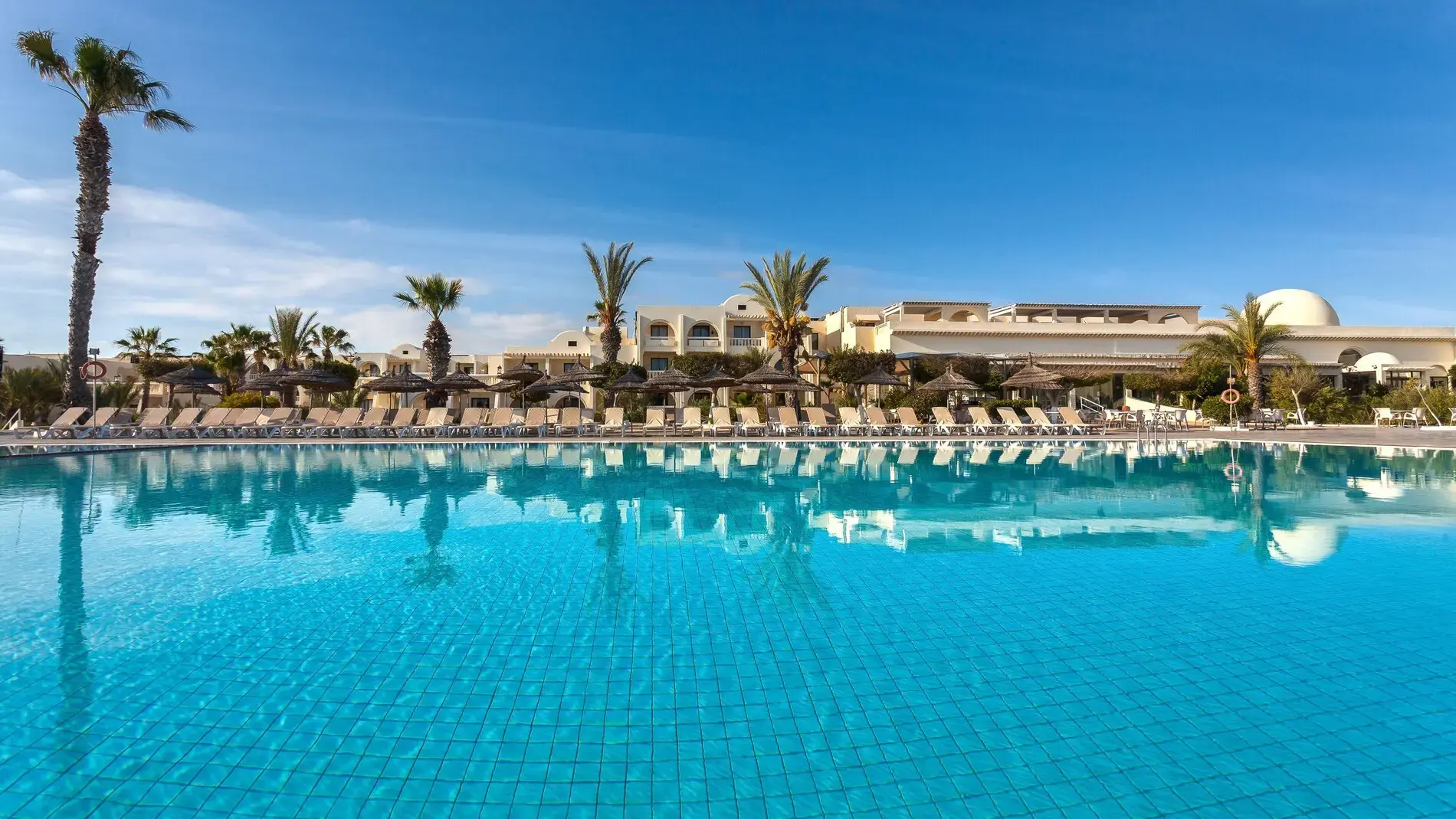 Голям открит басейн с шезлонги, палми и изглед към морето – Djerba Aqua Resort, Джерба