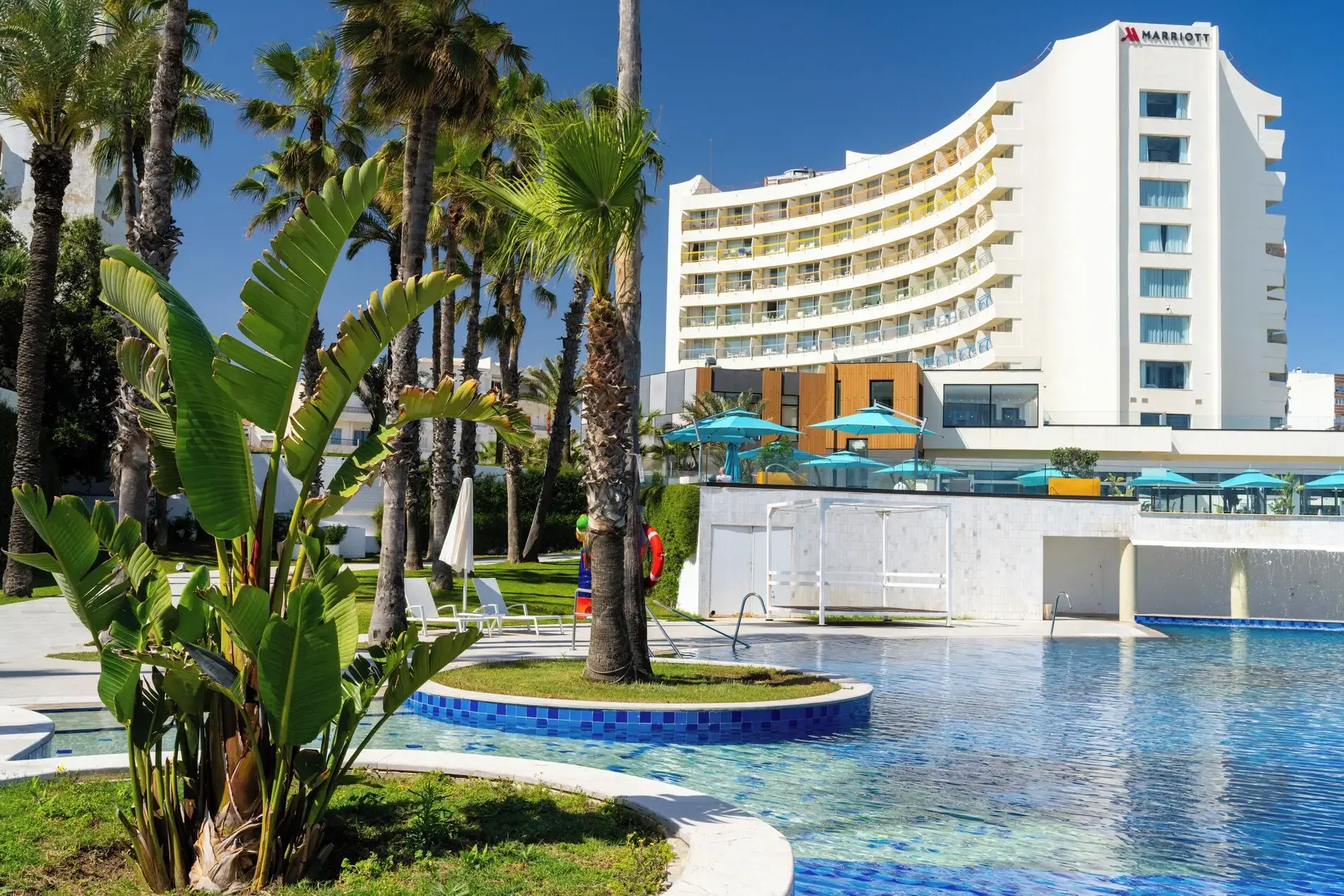 Сградата на хотела с басейн и палми през деня – Sousse Pearl Marriott Resort & Spa, Сус