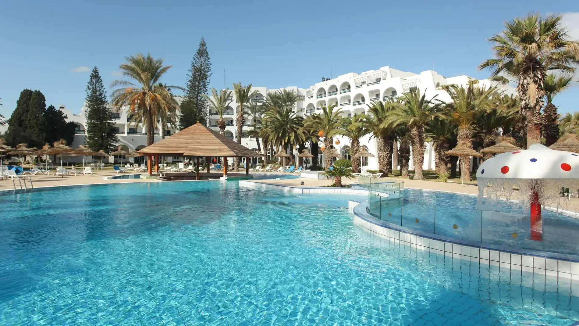 Открит басейн с палми, бар и бели сгради на хотела през деня – Marhaba Beach, Сус