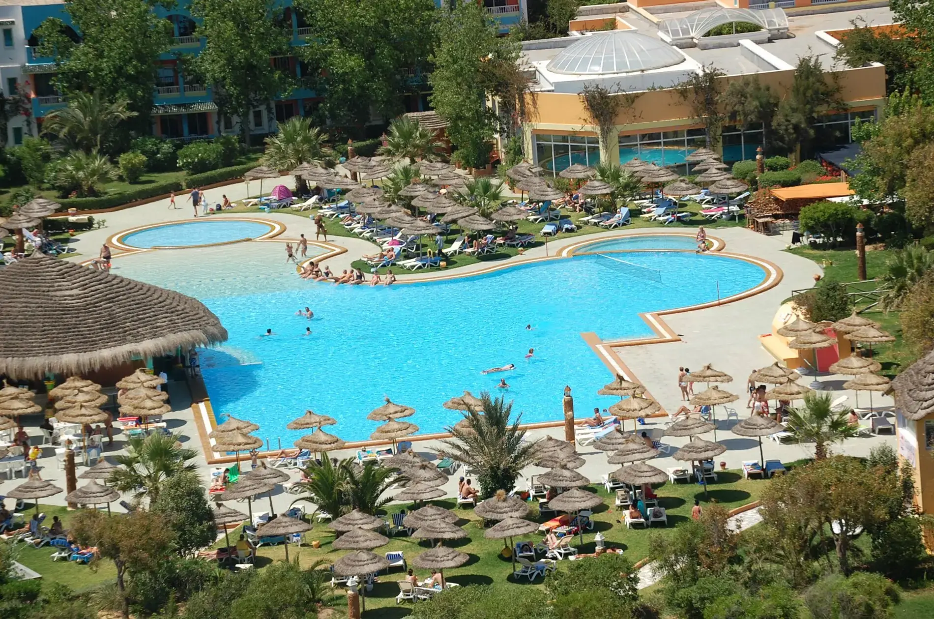Изглед отгоре към басейна с извита форма и стотици шезлонги – Caribbean World Mahdia, Махдия