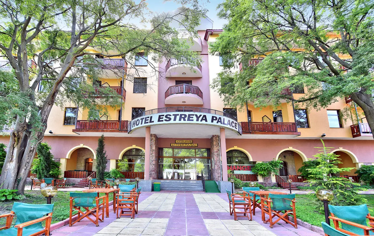Входът с надпис Hotel Estreya Palace и тераса с маси сред дървета – Естрея Палас, Св. Св. Константин и Елена