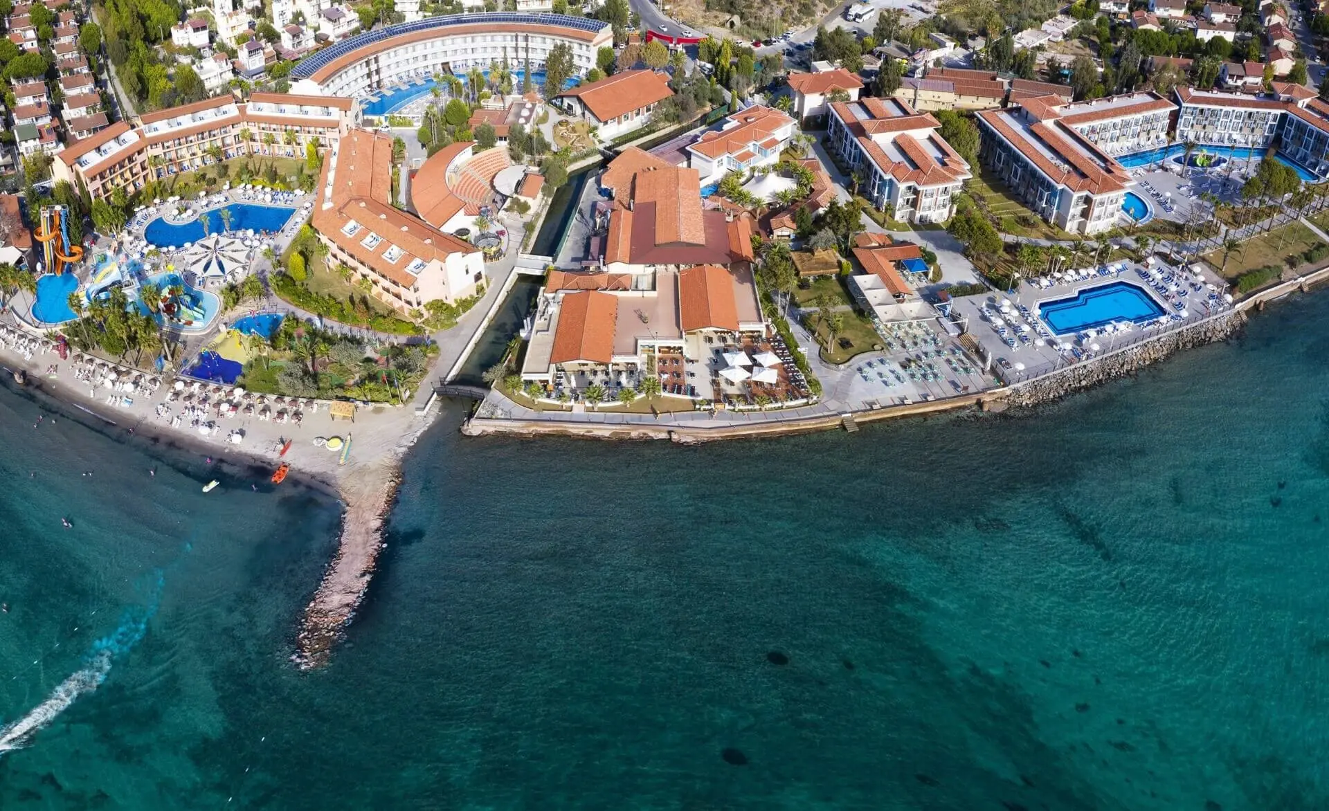 Изглед от дрон към кея, тюркоазеното море и басейните на хотела – Ephesia Holiday Beach Club, Кушадасъ