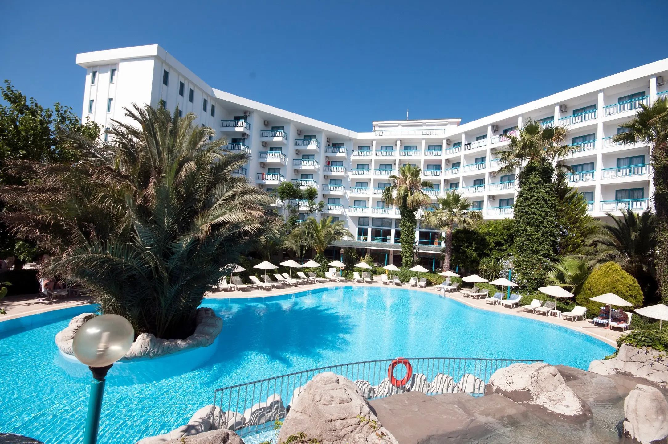 Басейн с палми и бялата сграда на хотела на фона на синьото небе – Tropical Beach Hotel, Мармарис