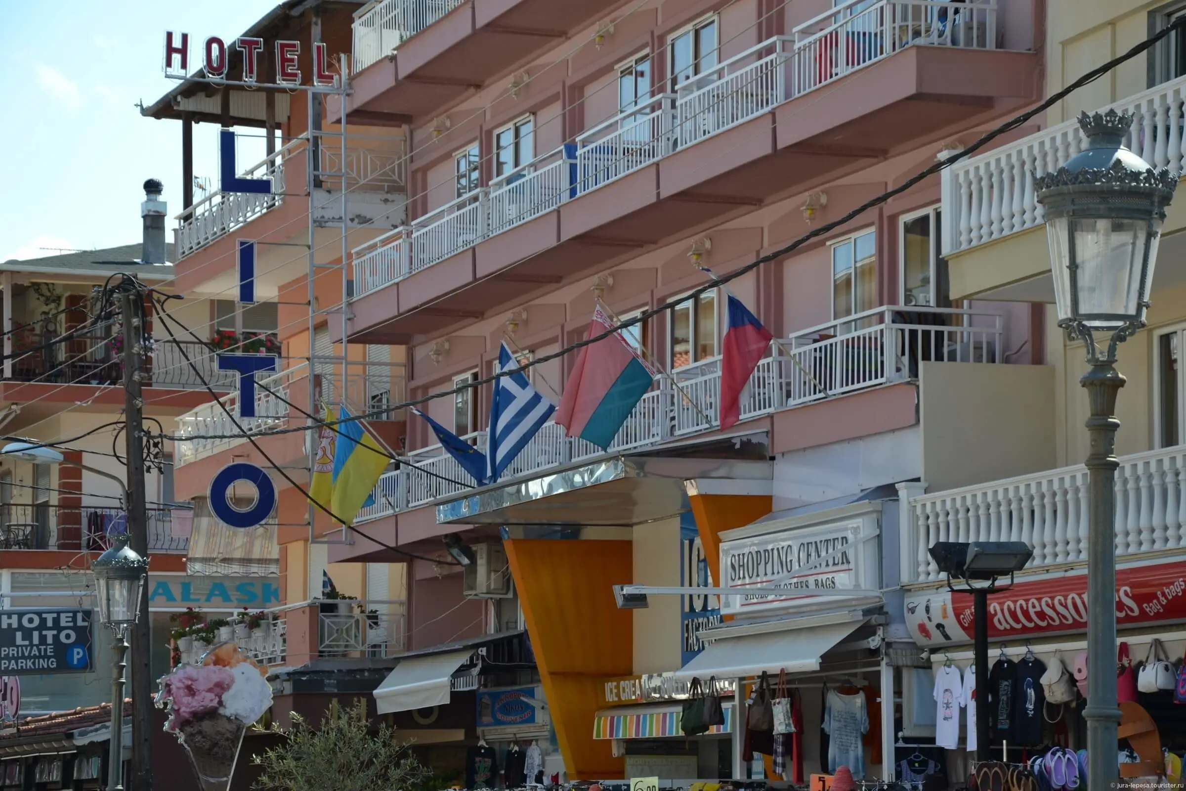 Фасадата на хотела с балкони и знамена на улицата – Boutique Lito, Олимпийска ривиера