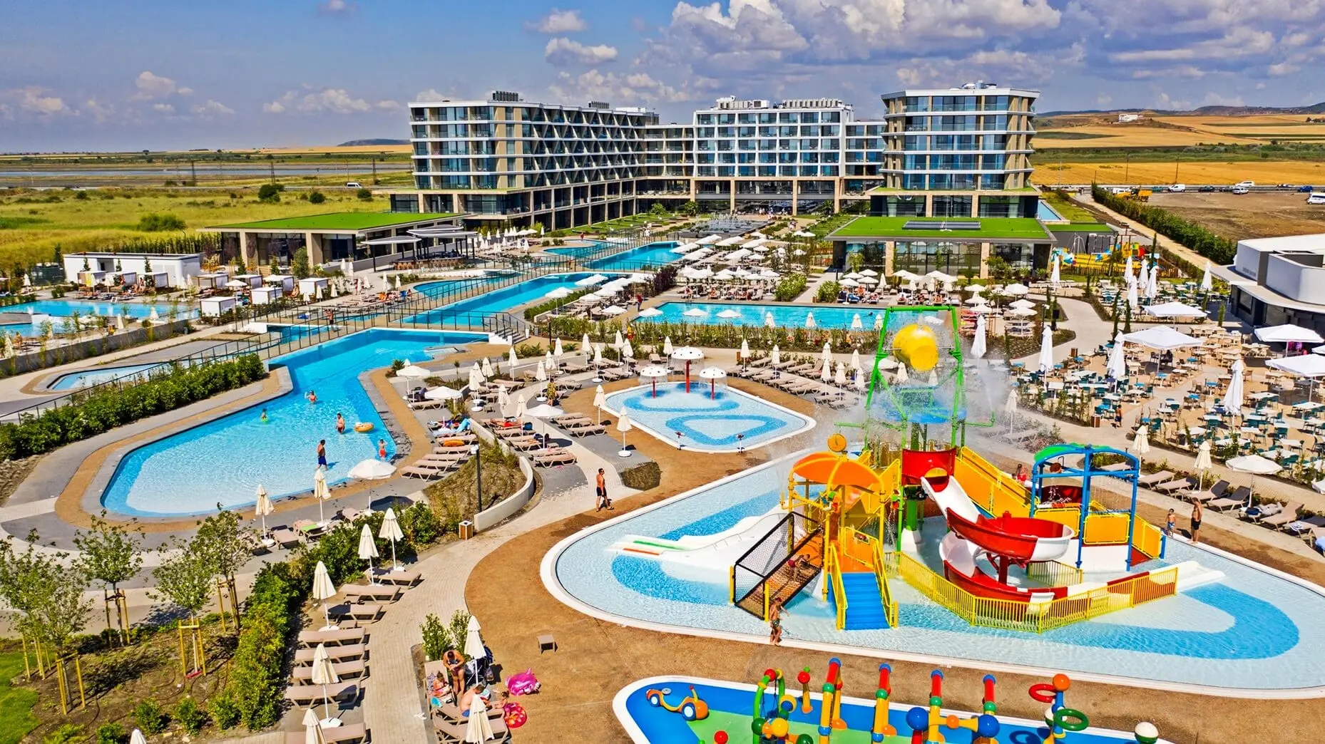 Аерофото на басейните, детските водни пързалки и хотелските сгради – Wave Resort, Ахелой