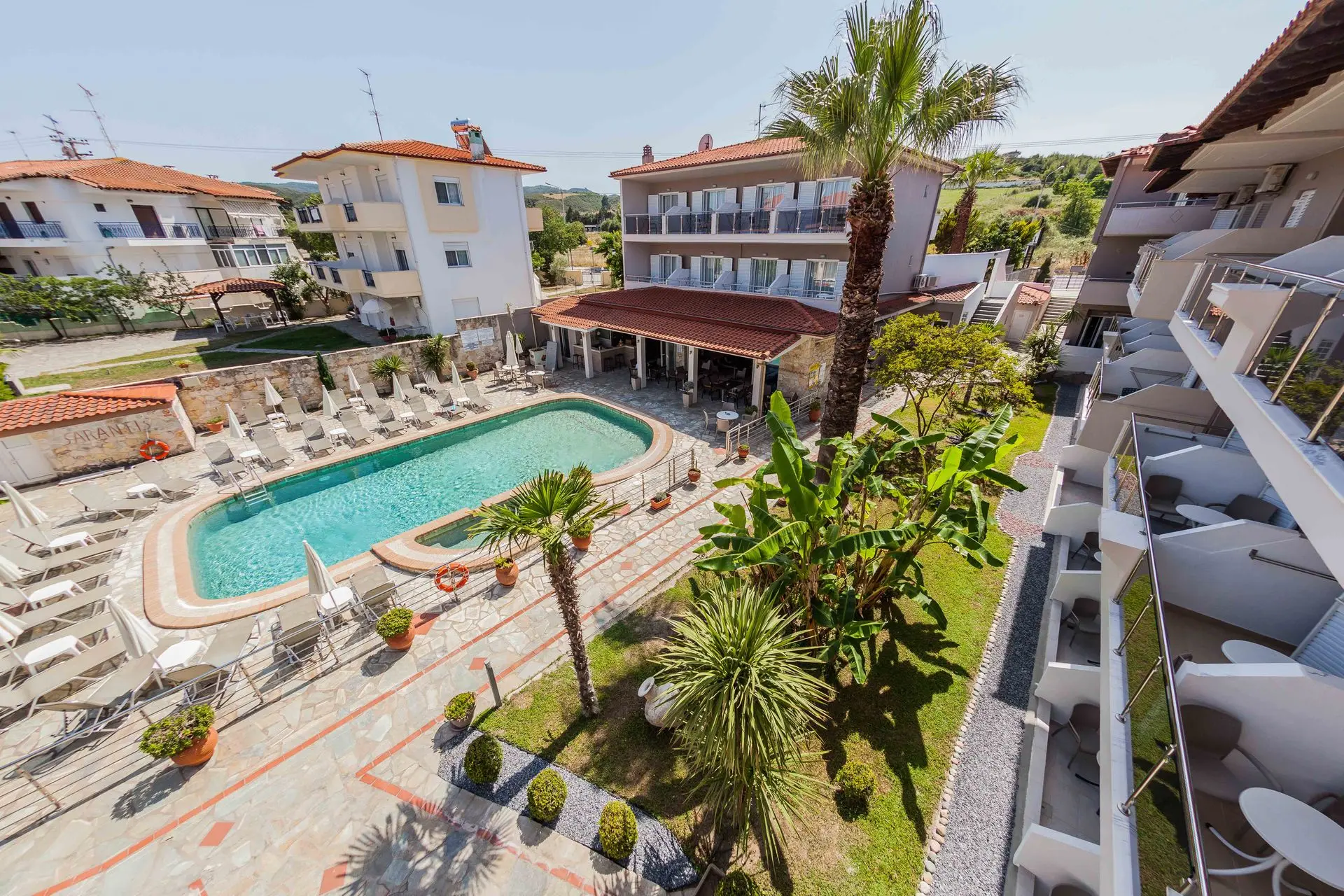 Басейнът и сградите с палми отвисоко – Sarantis Hotel & Suites, Касандра