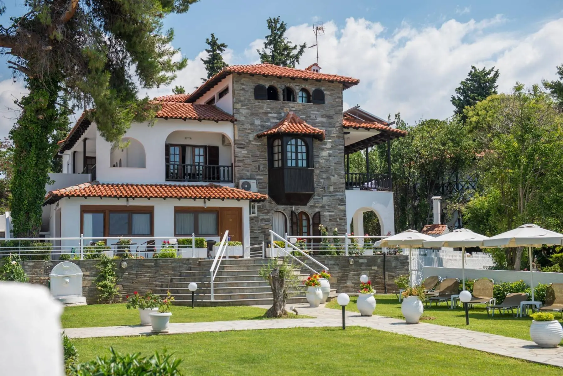 Каменна вила с кула и червен покрив сред зелена градина – Georgalas Sun Beach Villa, Неа Каликратия