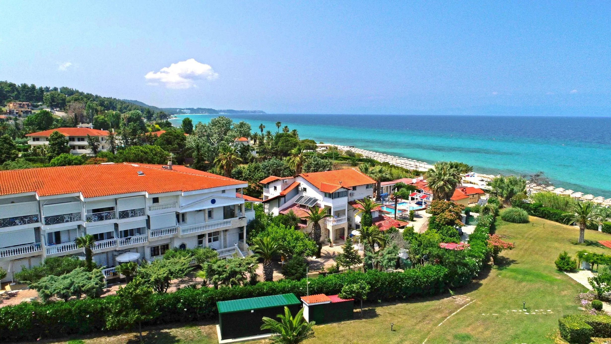 Сградите с червени покриви сред палми и морето отвисоко – Villa George Hotel Apartments, Касандра